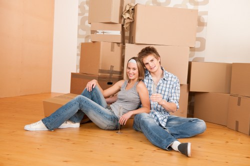 Movers carrying furniture in a London apartment building with narrow stair access