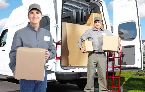Professional movers packing and protecting household items before transport
