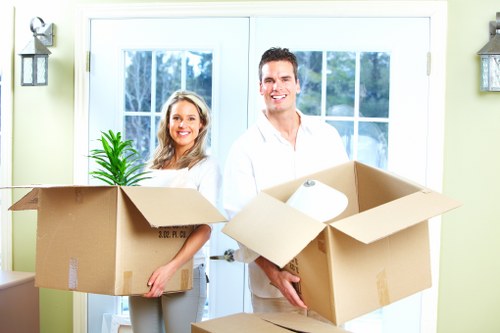 Removal professionals carrying furniture through a London flat building